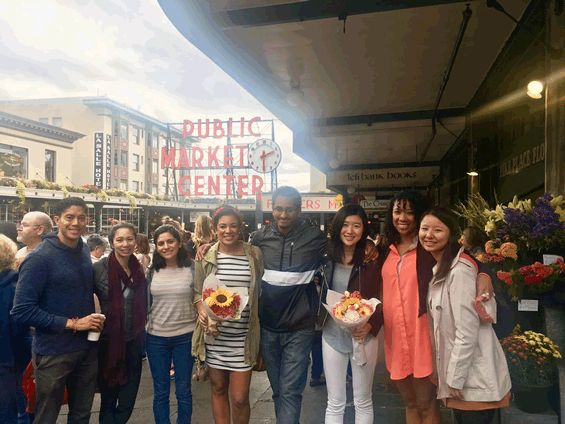 Members of the Resident Diversity smile in front of the Pike Place Market in downtown Seattle.